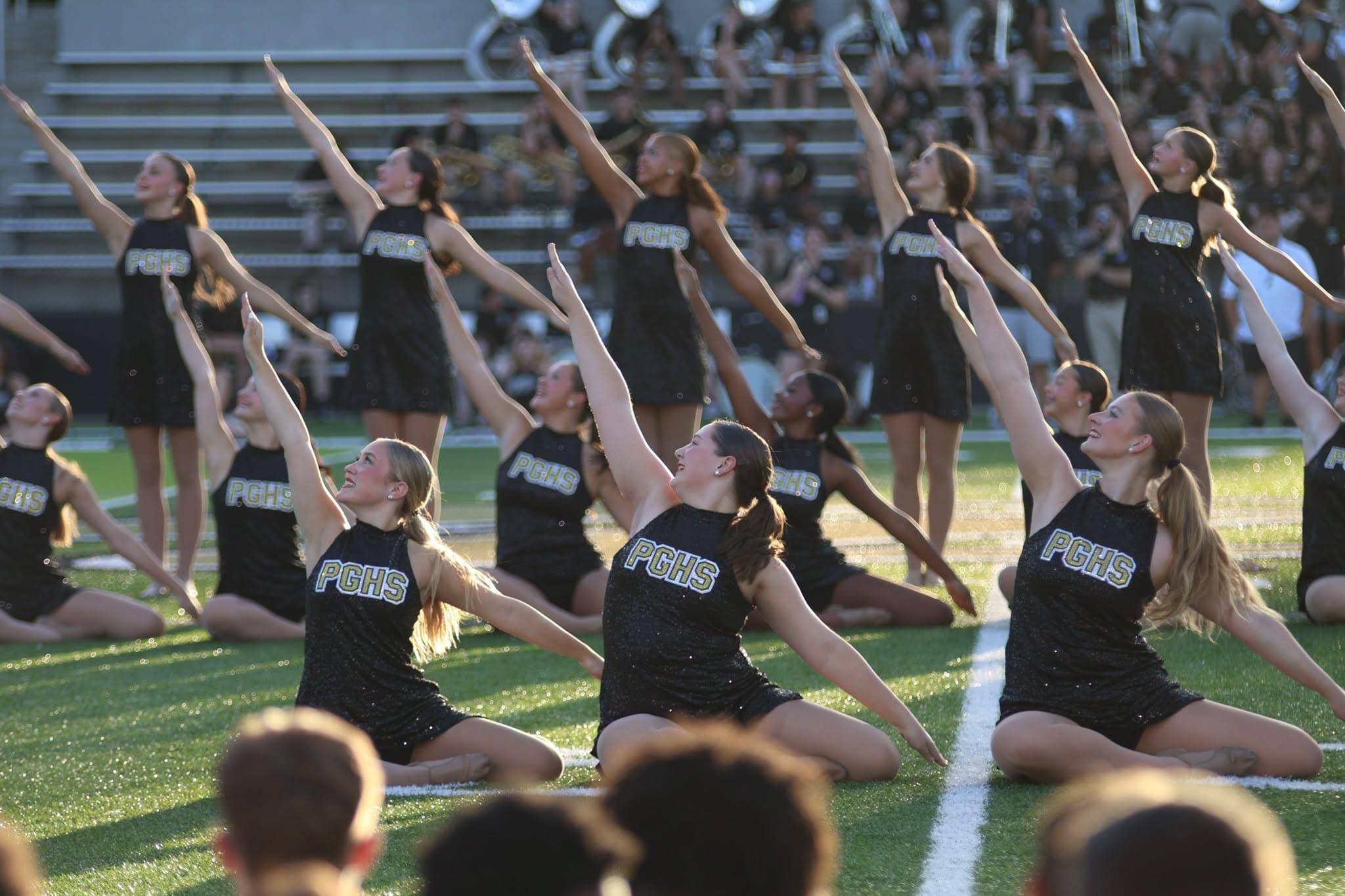 cheerleaders smiling together with pom poms