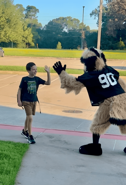 hawk mascot giving high five to a young student