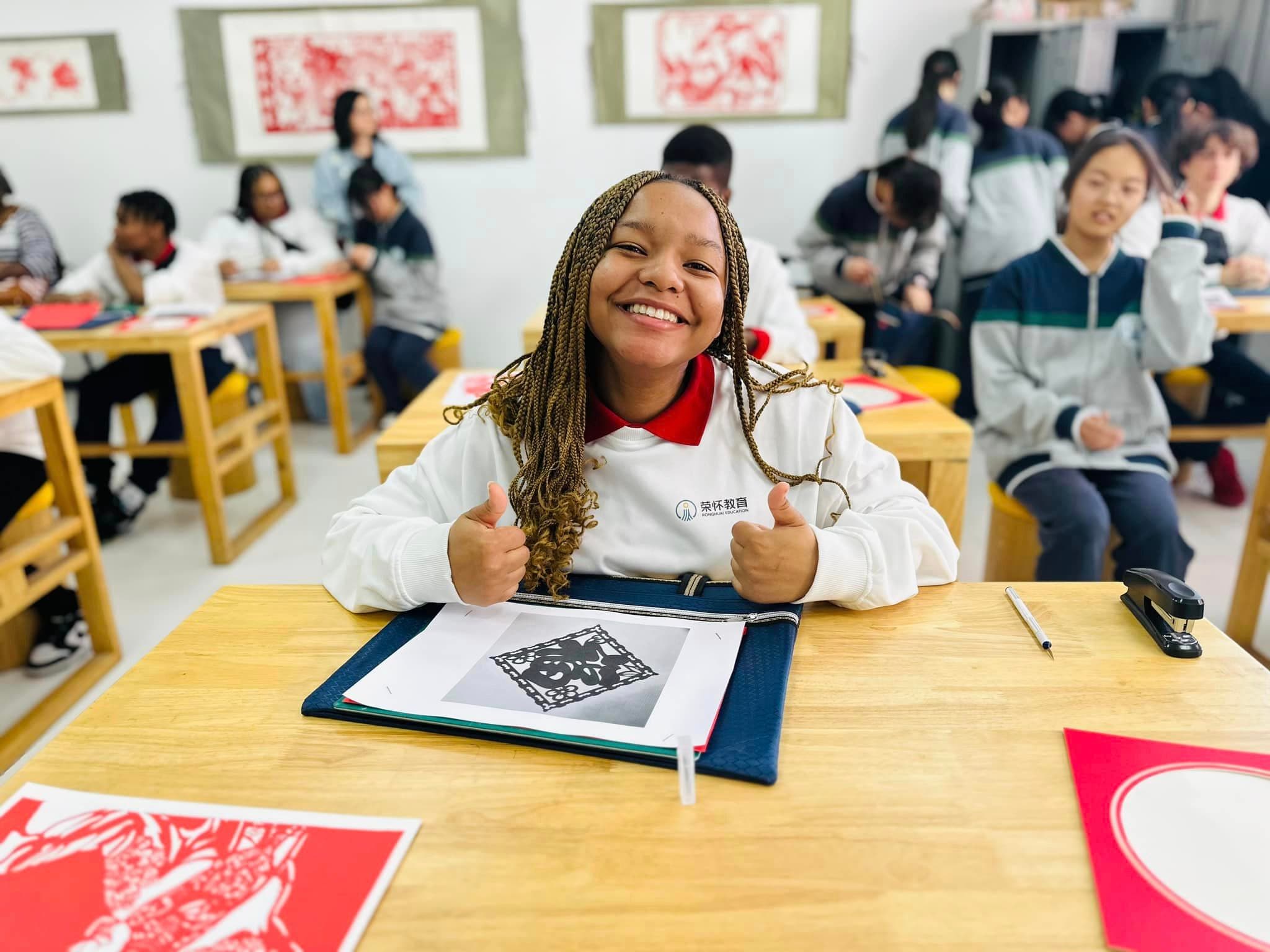 girl in classroom giving thumbs up