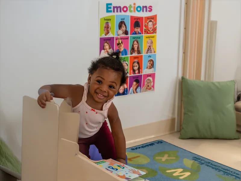 Smiling child peeking from classroom doorway