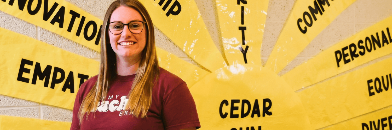 A person wearing glasses and a maroon shirt stands in front of a yellow background with radiating text.