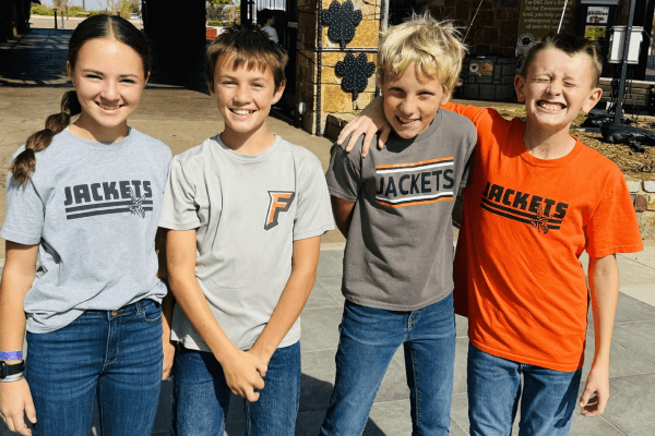 Four friends pose for a photo, all wearing shirts with the word 'Jackets' on them.