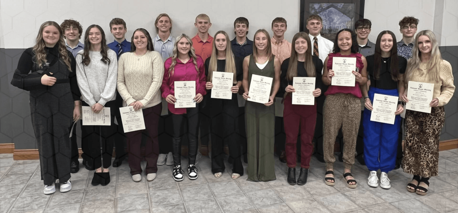 A group of people stand together, holding certificates and smiling for a photo.