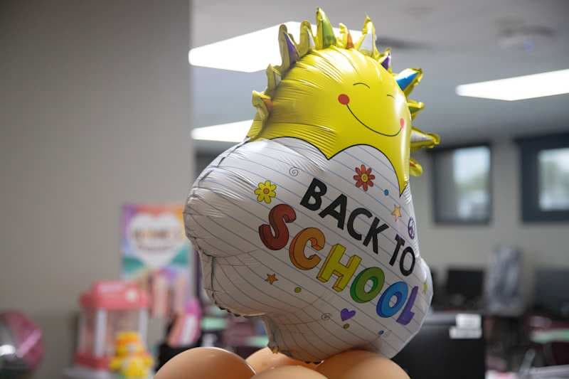 a balloon with a sun that says back to school