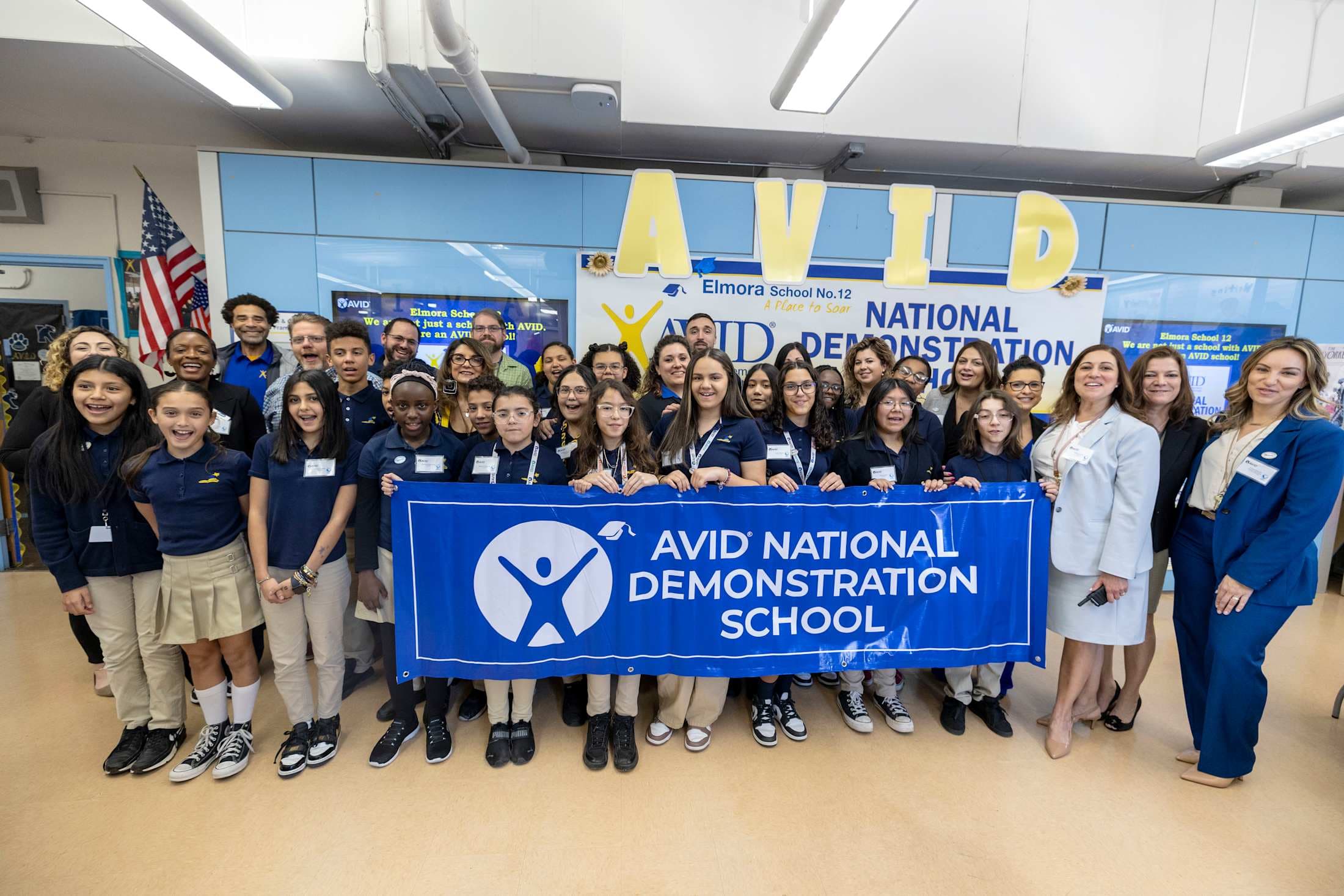 Elmora School No. 12 students and administrators, EPS administrators, and AVID representatives hold AVID National Demonstration School banner