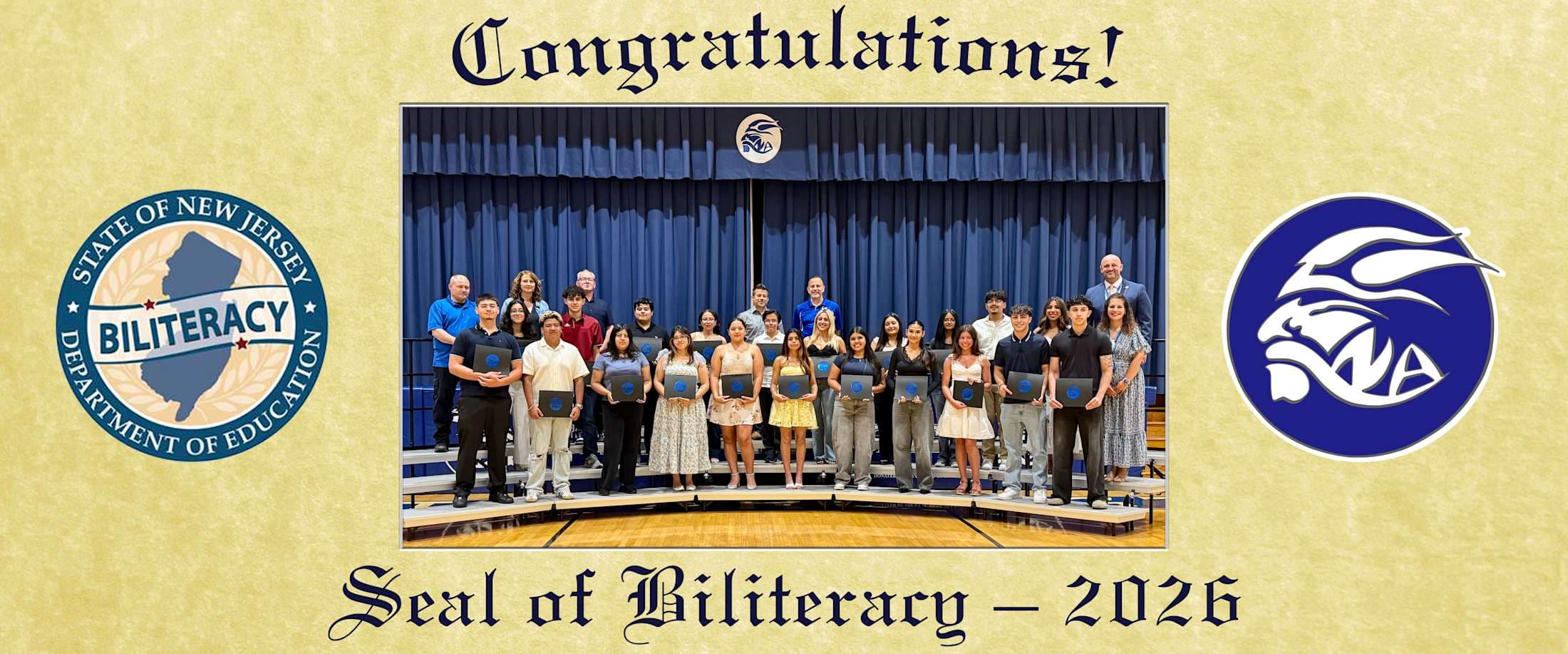 A group of students and adults stand on risers in front of a blue curtain, holding certificates, with the State of New Jersey Seal of Biliteracy and a school logo on either side.