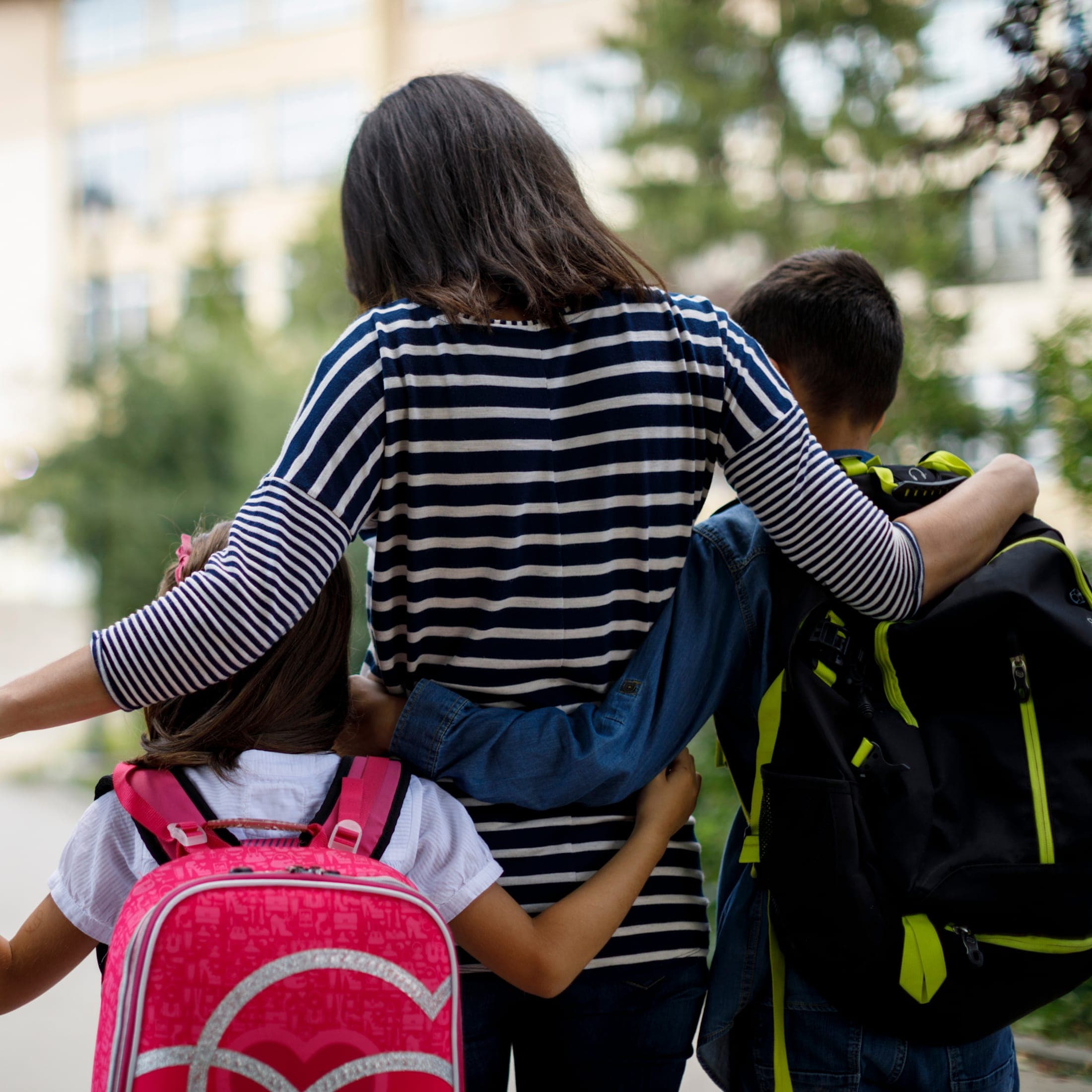 A mother walking her daughter and son to school