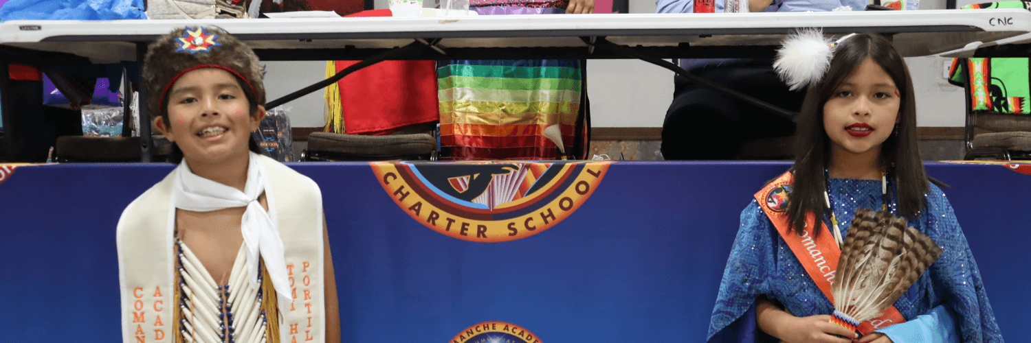 Two women smile at the camera, standing in front of a colorful backdrop.