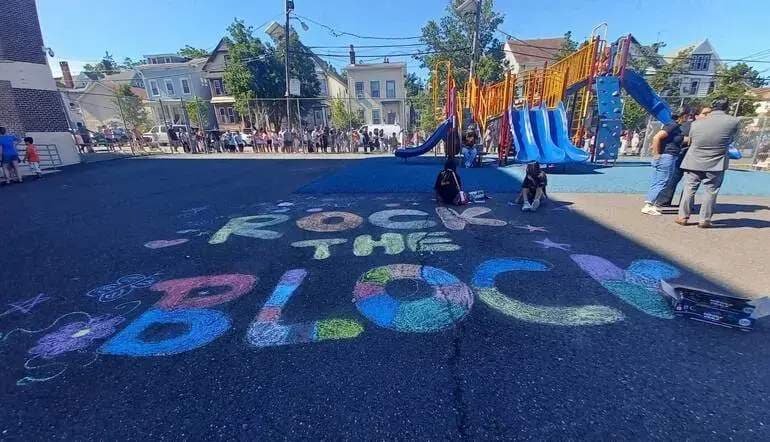 blacktop chalk art wit the words rock the block