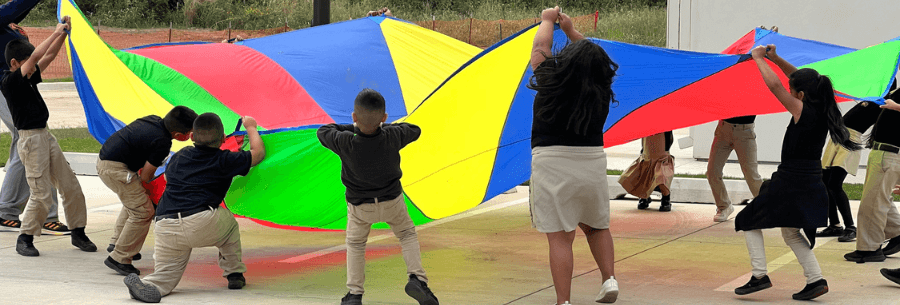 ASTEC Elementary students play with colorful parachute.