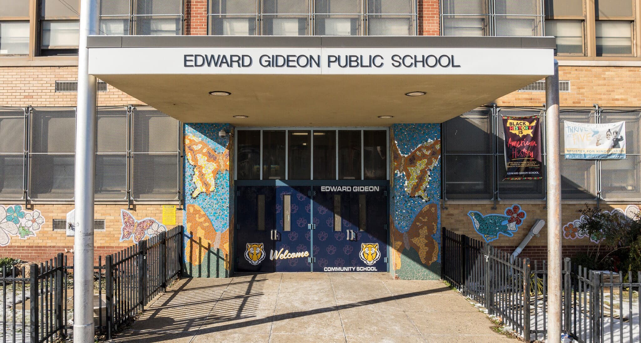 Main entrance of Edward Gideon School featuring colorful mosaic artwork and welcoming tiger graphics.