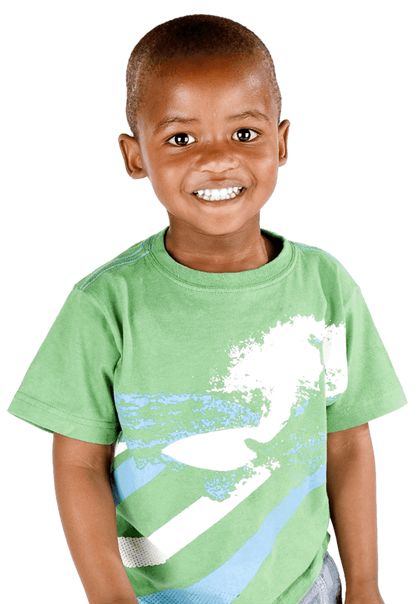 A smiling young boy in a green graphic t-shirt stands against a purple background, looking cheerful and confident.