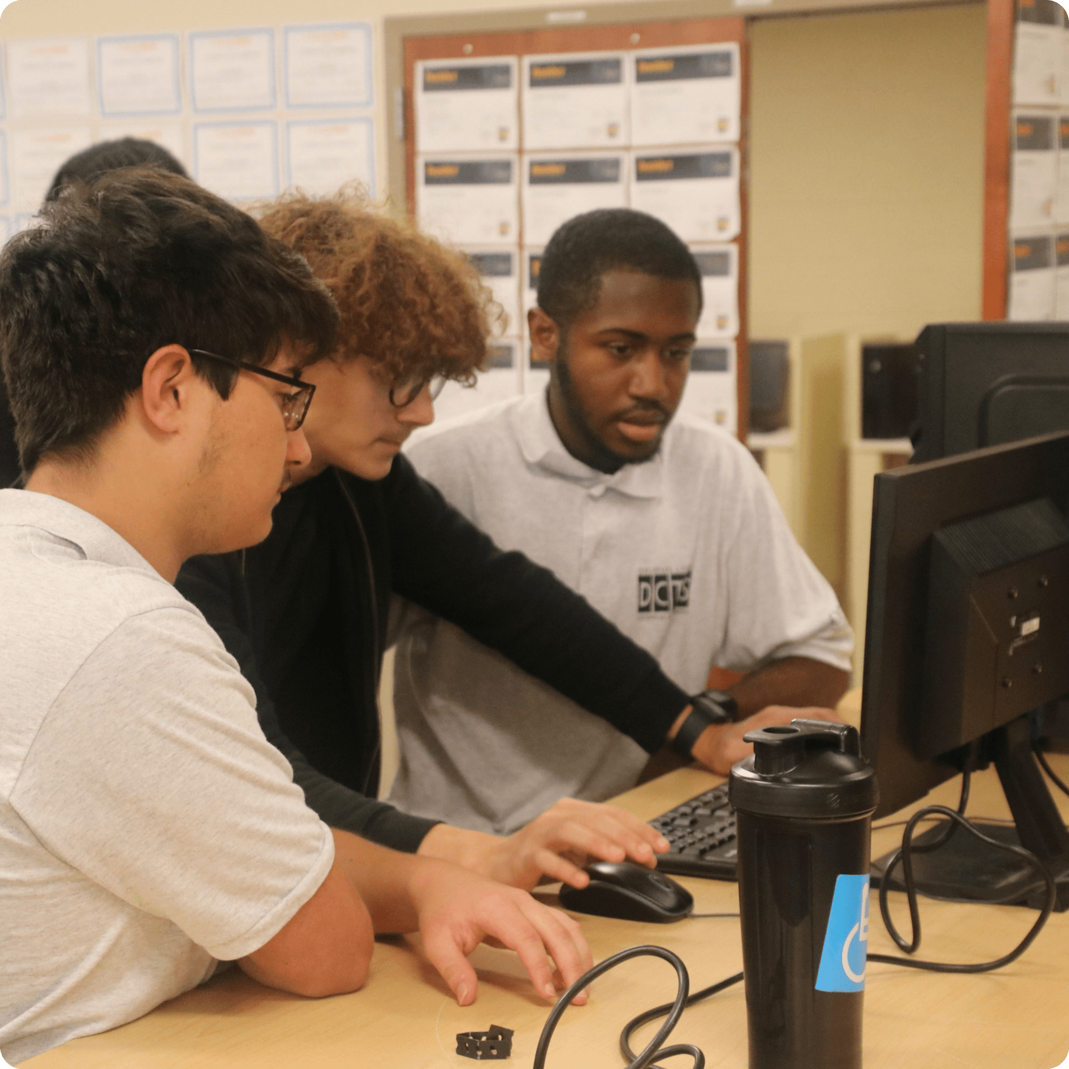Students collaborate at a computer workstation in the networking and IT lab.