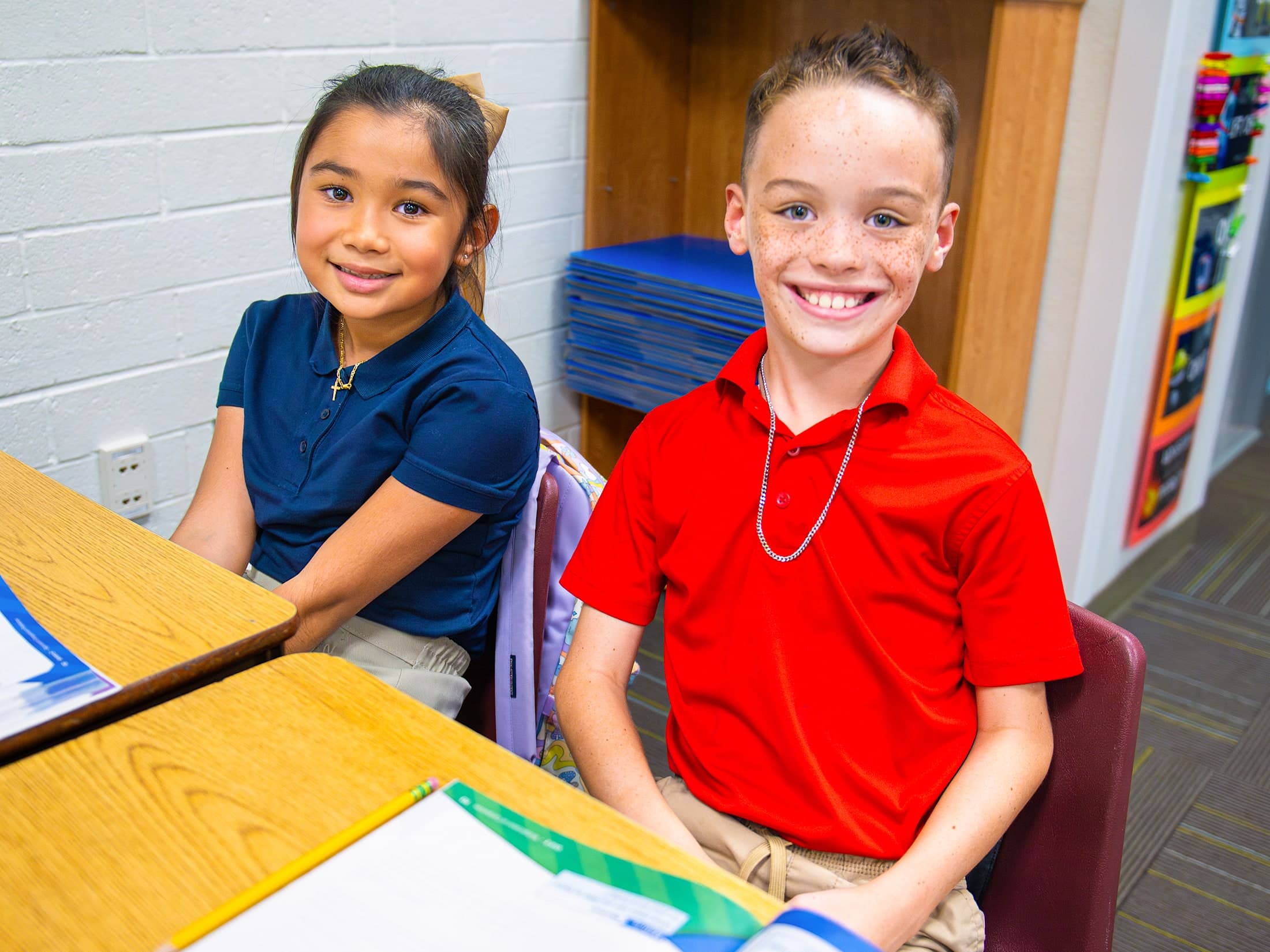 Two MTA Students smiling at their desks