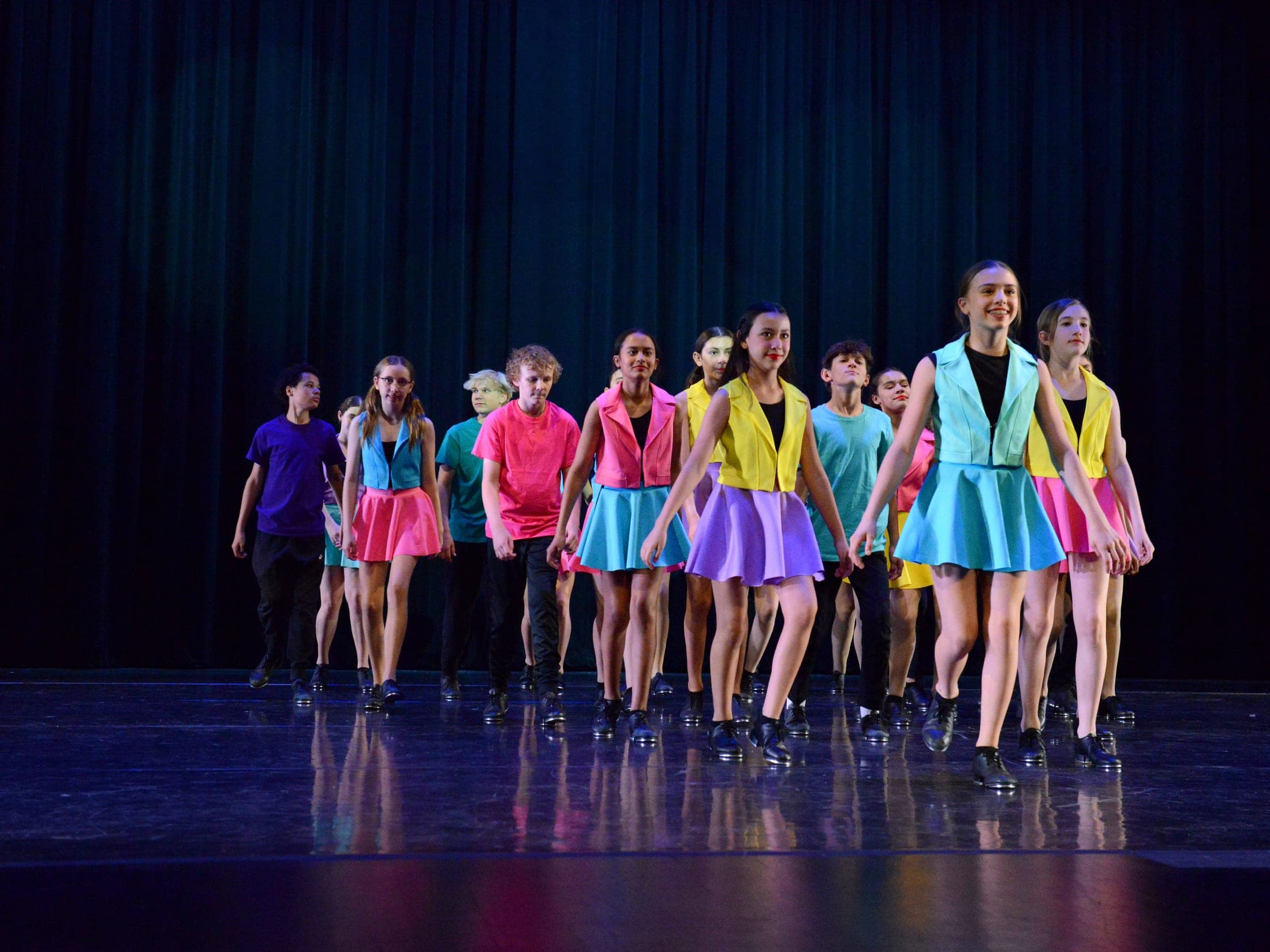 Advanced Tap students during dress rehearsal in brightly colored outfits
