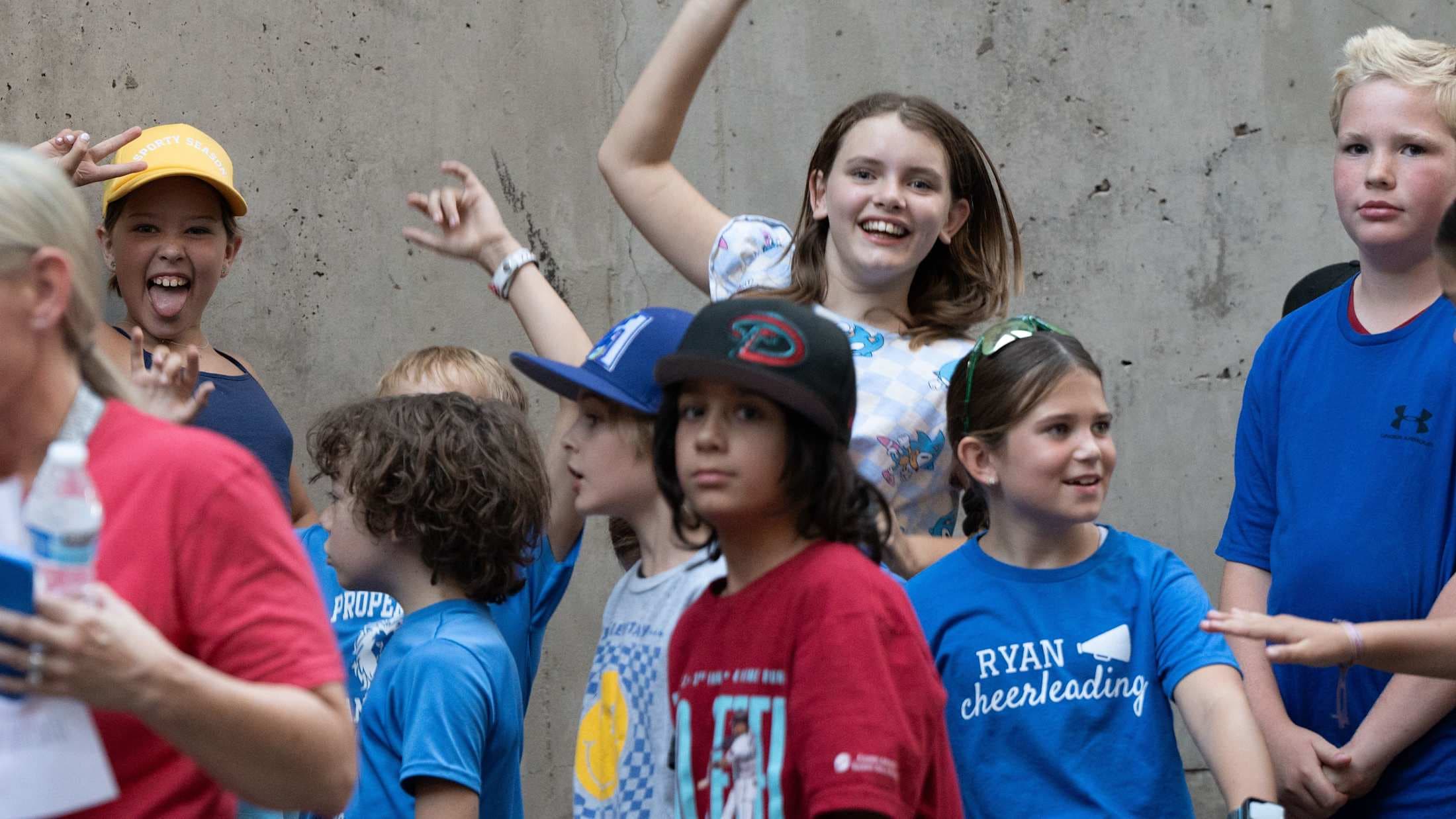 Elementary students jump and pose for a camera before a Diamondbacks baseball game.