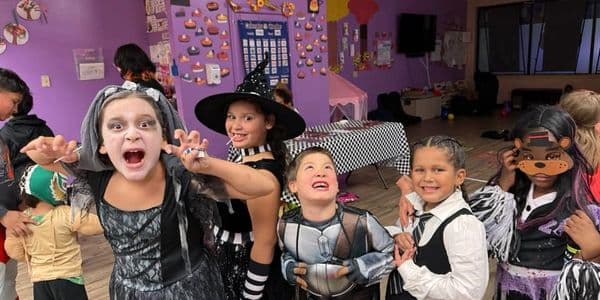Kids in Halloween costumes having fun indoors.