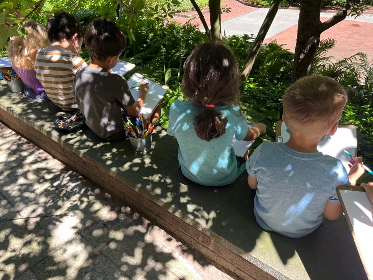 A group of children sitting on top of a bench.