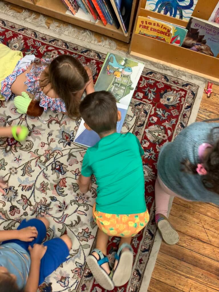 A group of children sitting on the floor reading books.