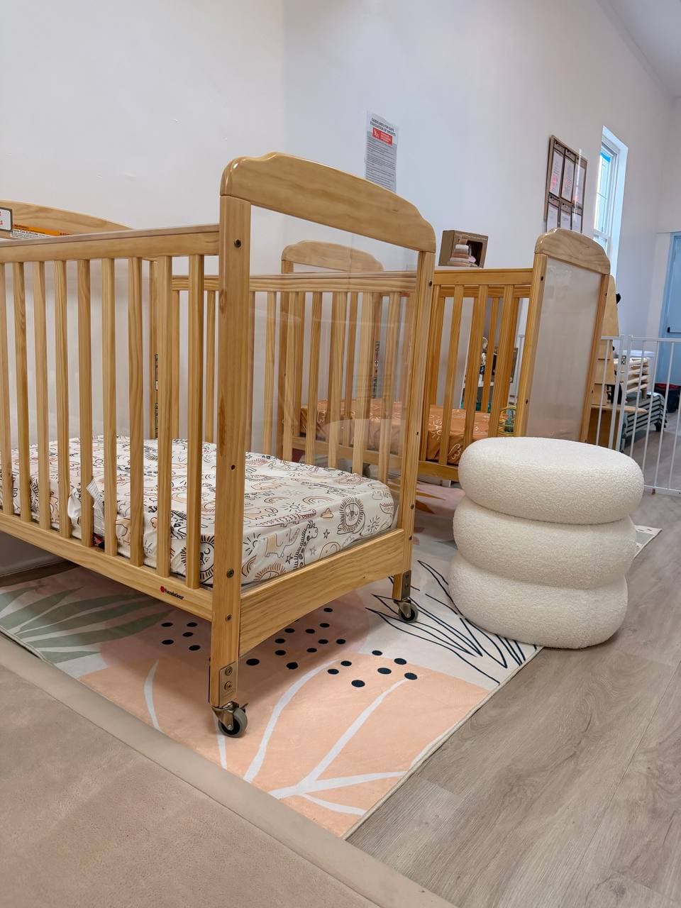 Infant care area with wooden cribs and soft rugs