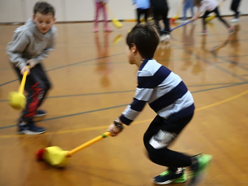 Students playing hockey in the gym