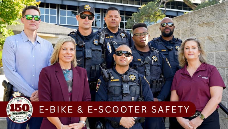 Police officers and school personnel standing together to talk about ebikes and escooter safety