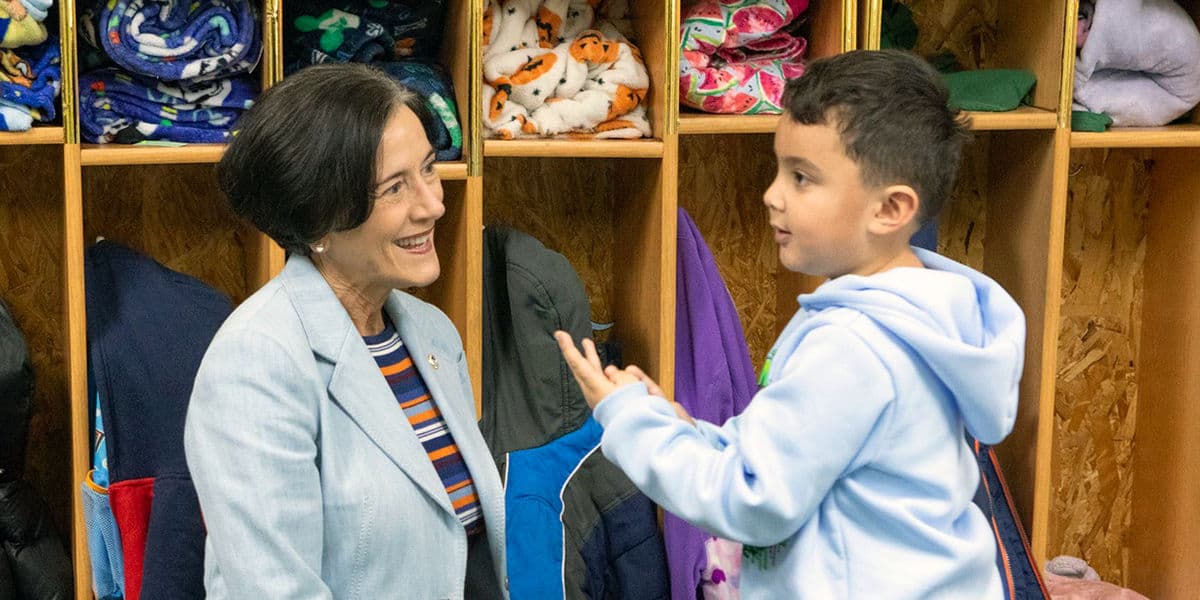 PA DHS Secretary Val Arkoosh knelling to speak with a child.