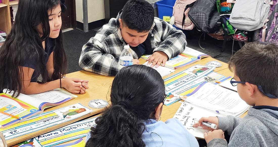 Students sitting around a teacher in a classroom