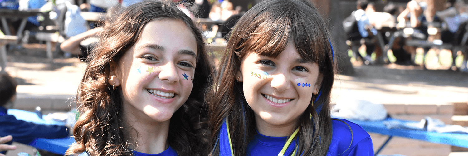 Two young people smile at the camera, possibly at an event.