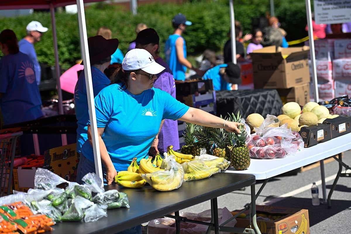 Volunteers distribute food during the summer food program pick-up