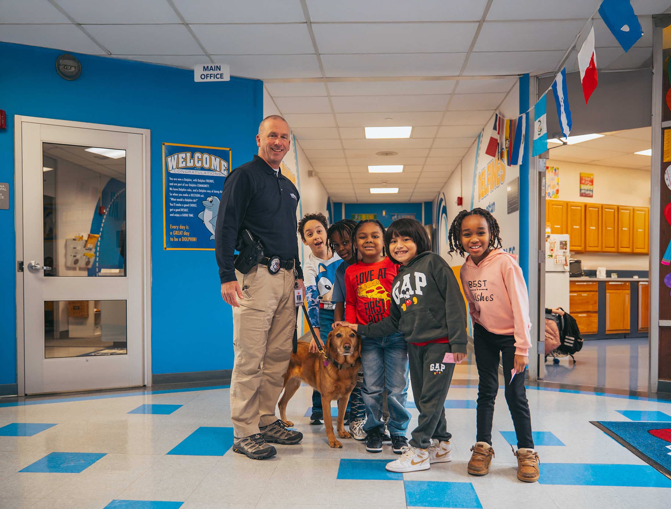 students smiling with constable's dog