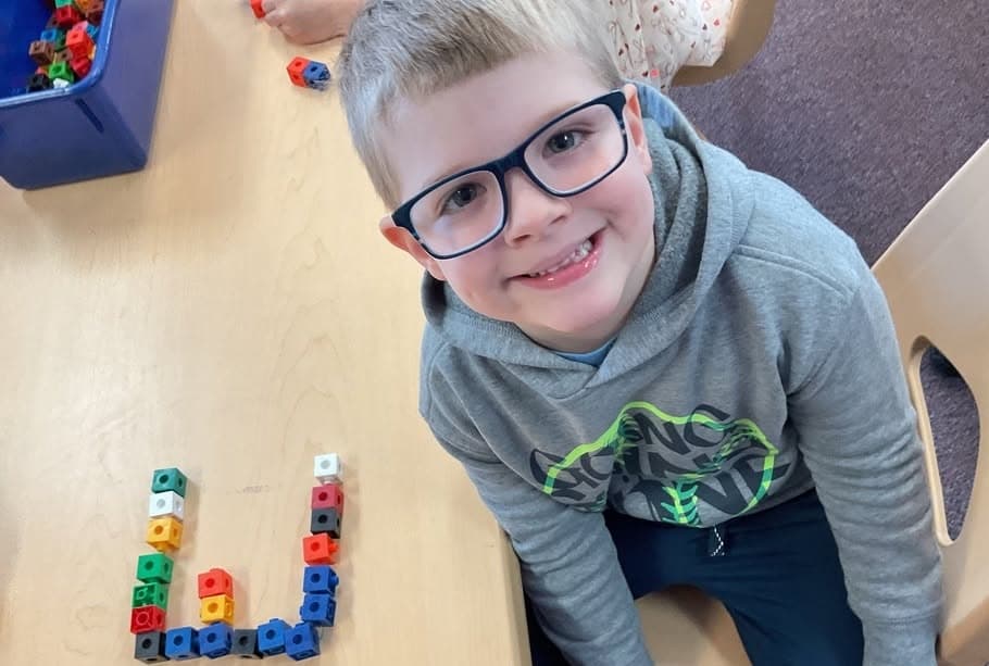 child using blocks and smiling at preschool and daycare at cadence academy preschool smyrna, delaware
