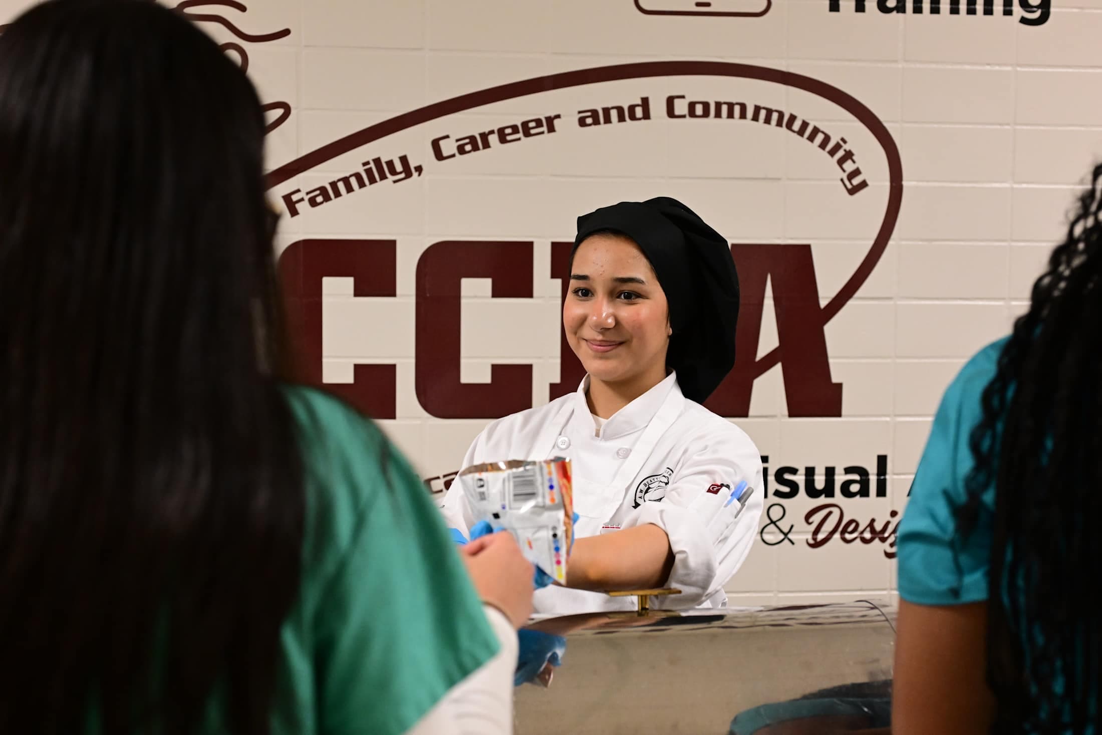 student smiles while talking with visitors