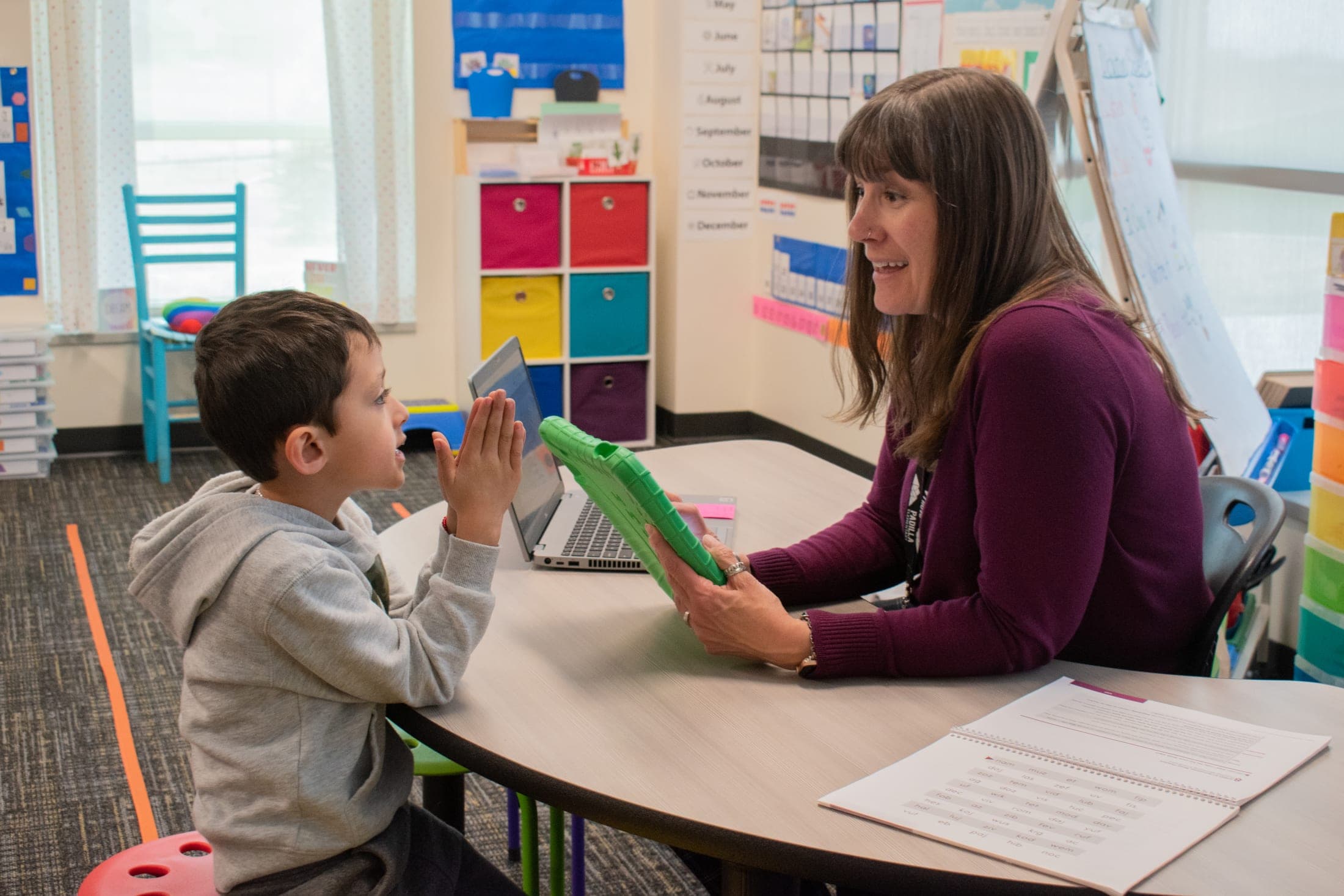 woman at desk talking with a young boy