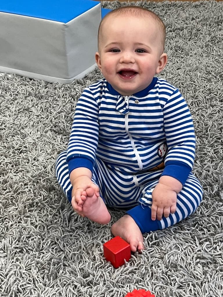 Smiling infant in the Amici Montessori infant program classroom