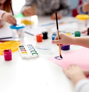 Children painting with purple paint
