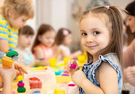 Toddlers in class playing with clay