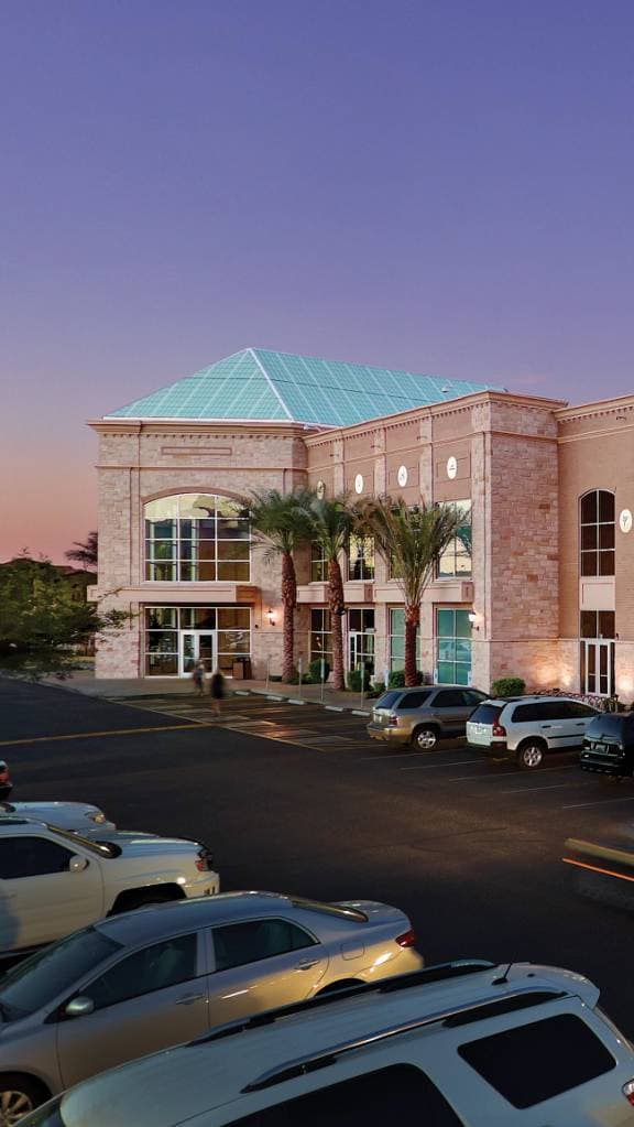 the exterior of a Life Time location with palm trees