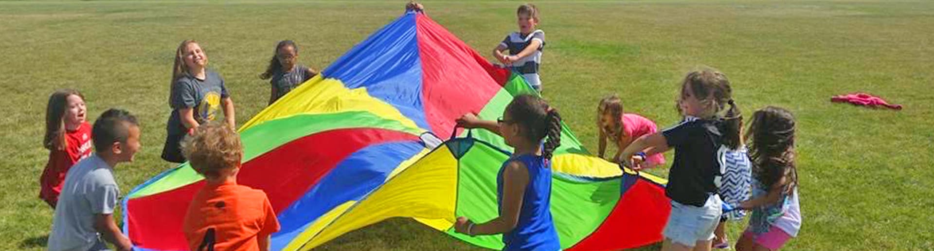 Children playing with a group parachute during an activity.