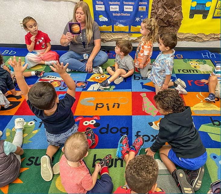 Teacher leading a classroom activity with children.