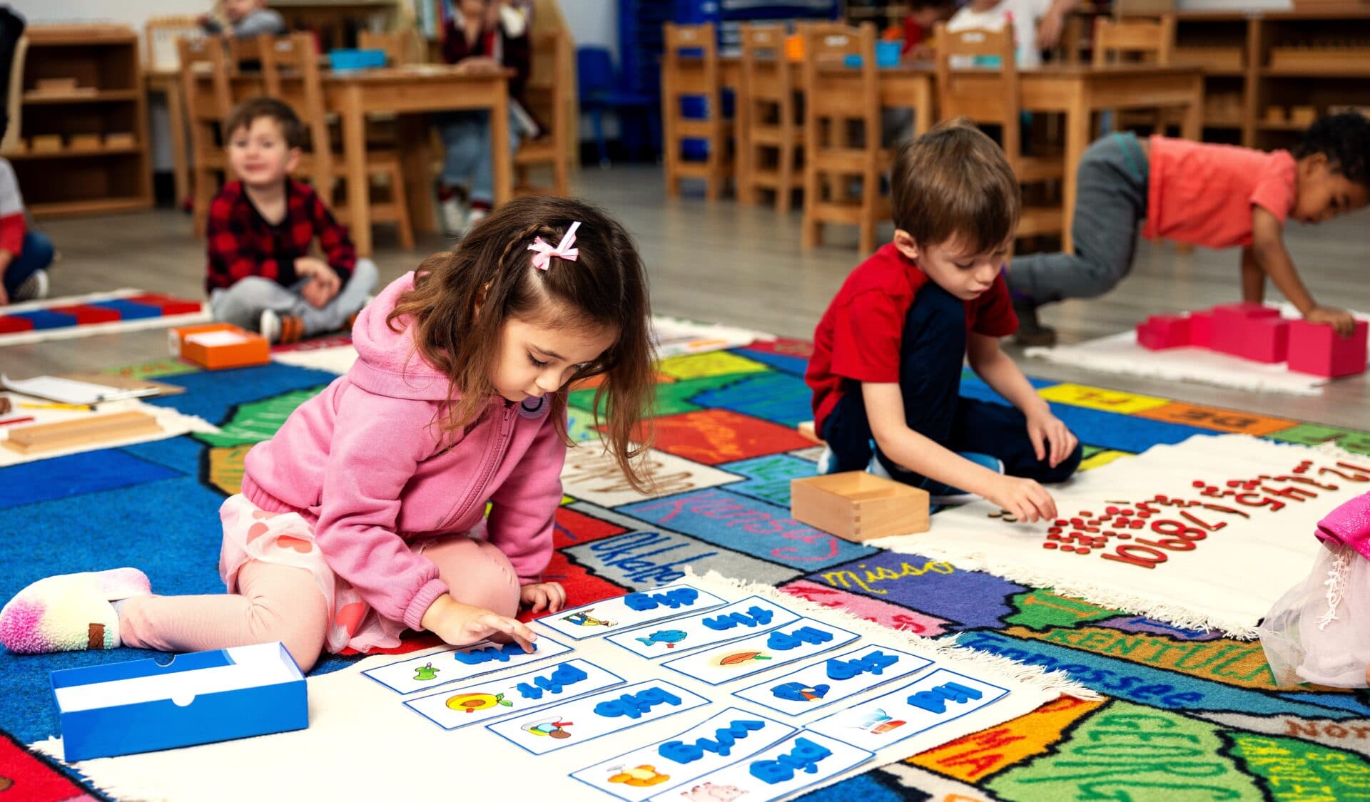 Preschoolers learning letters on colorful mat.
