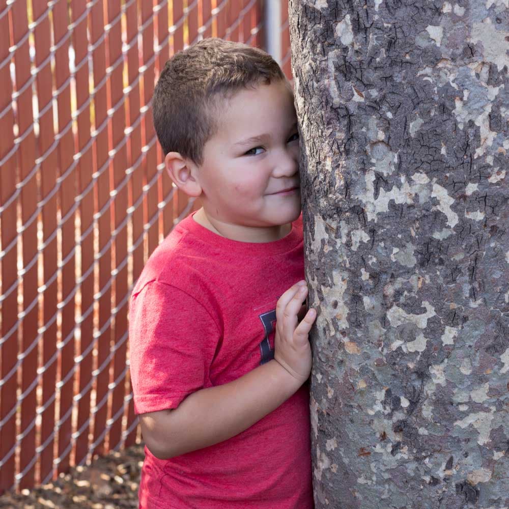 Child hiding in a classroom play area.