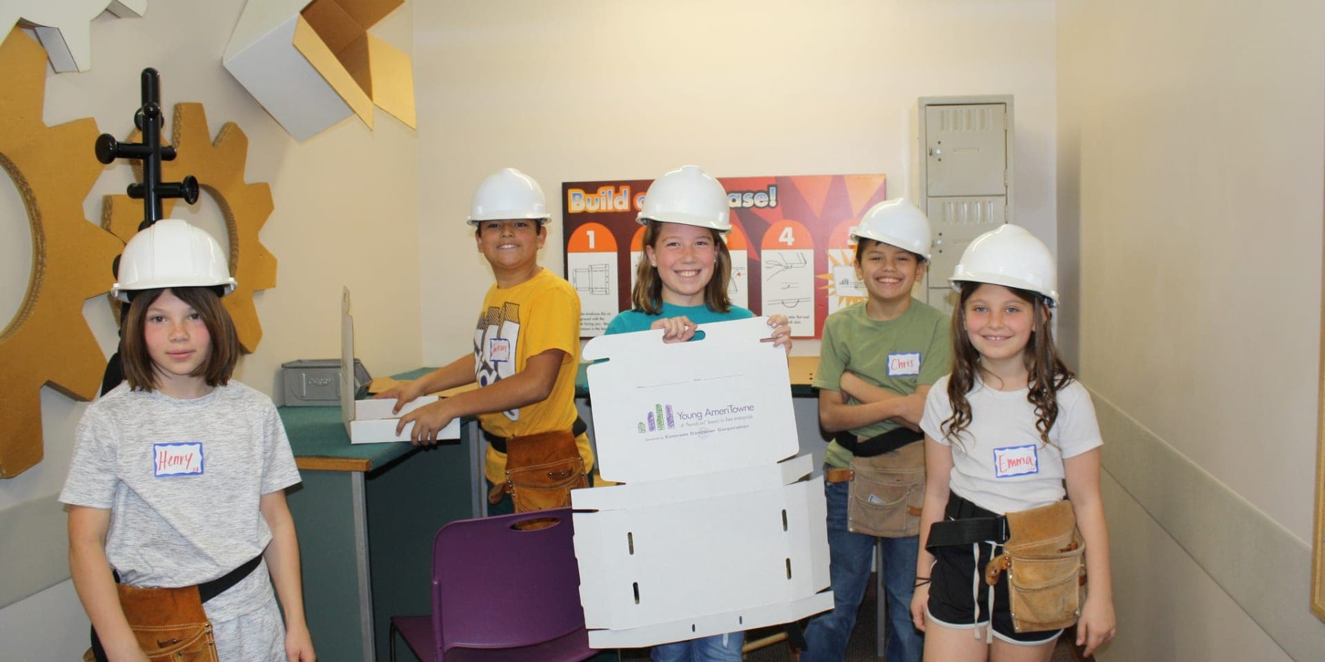 group of kids posing for a photo wearing construction hats