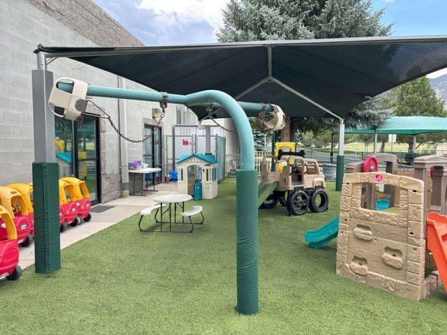 Playground with shade and play equipment for children.