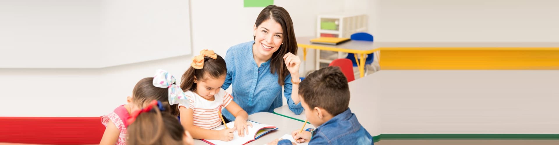 teacher smiling while looking over her students